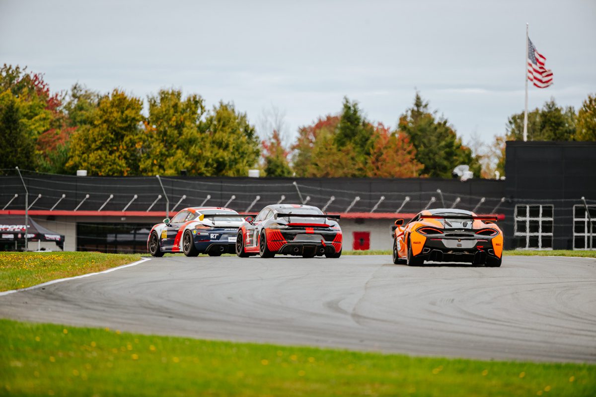 A group of race cars are racing through a turn