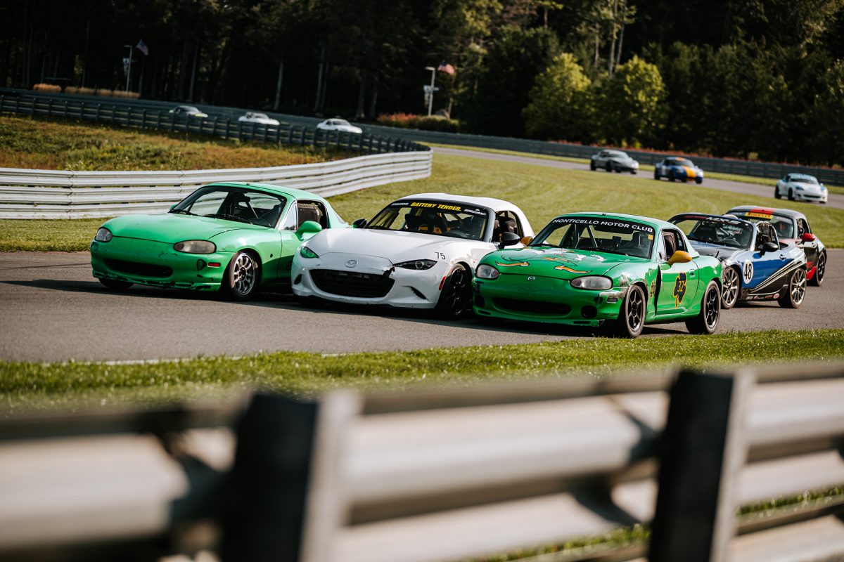 3 mazda Miatas side-by-side, racing down the track