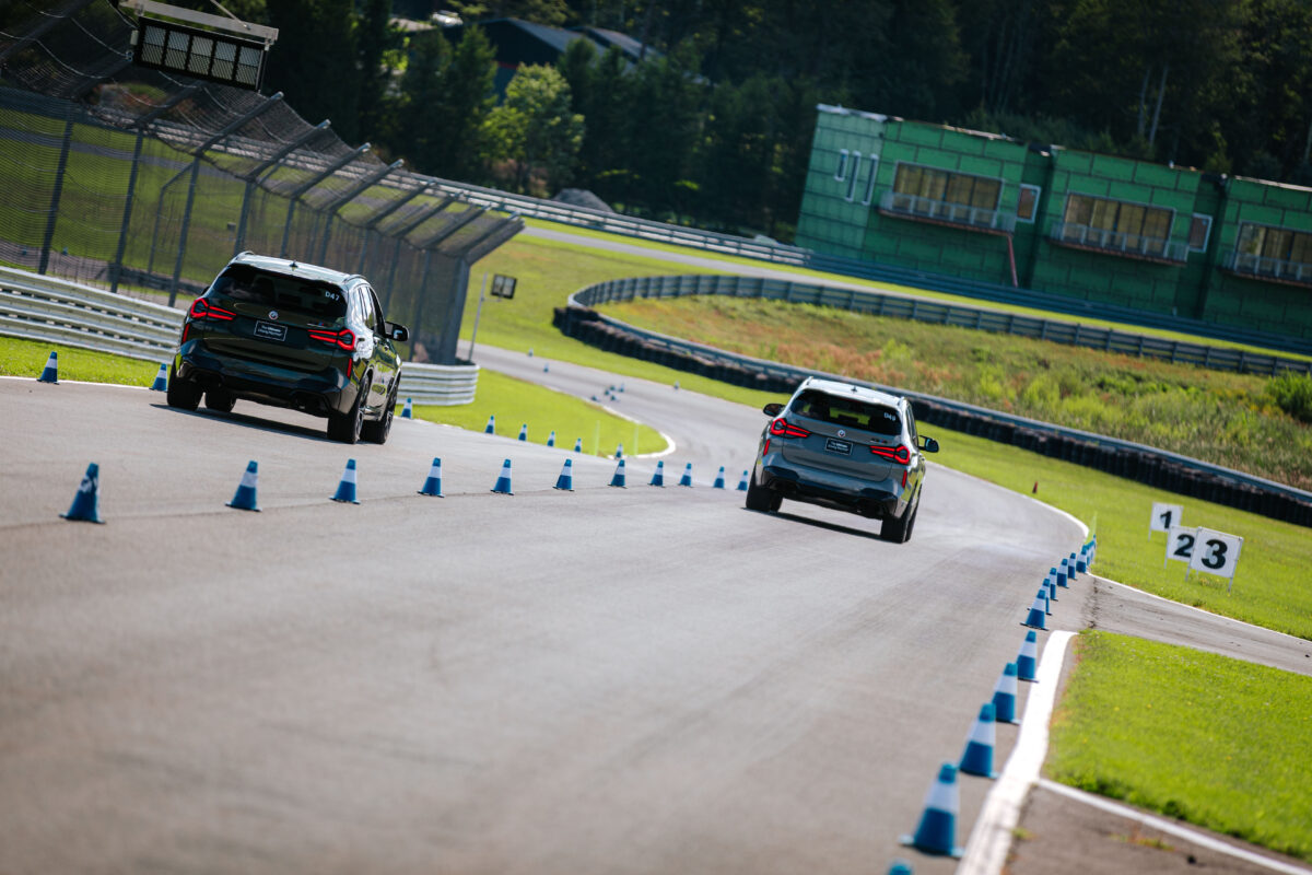 Two BMW SUVs race down the track