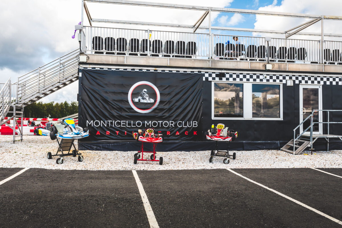 3 Go karts are positioned in front of the Karting Facility Building